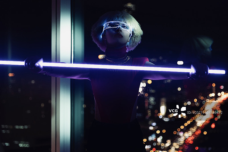 赛博朋克系列：城市灯火下未来女人拿着发光剑图片素材