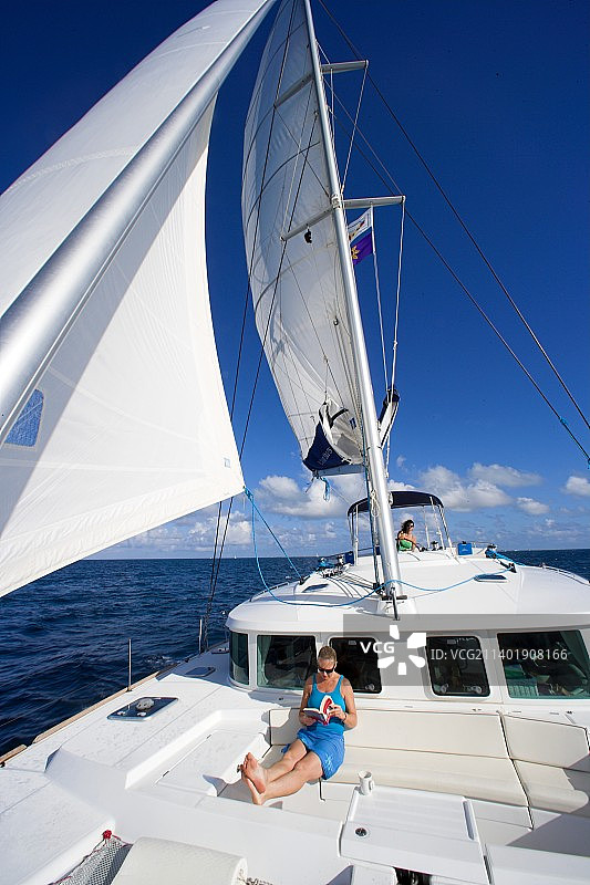 在船甲板上阅读的女人图片素材