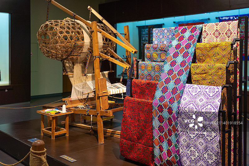 广西民族博物馆展品织布机与民族衣物图片素材
