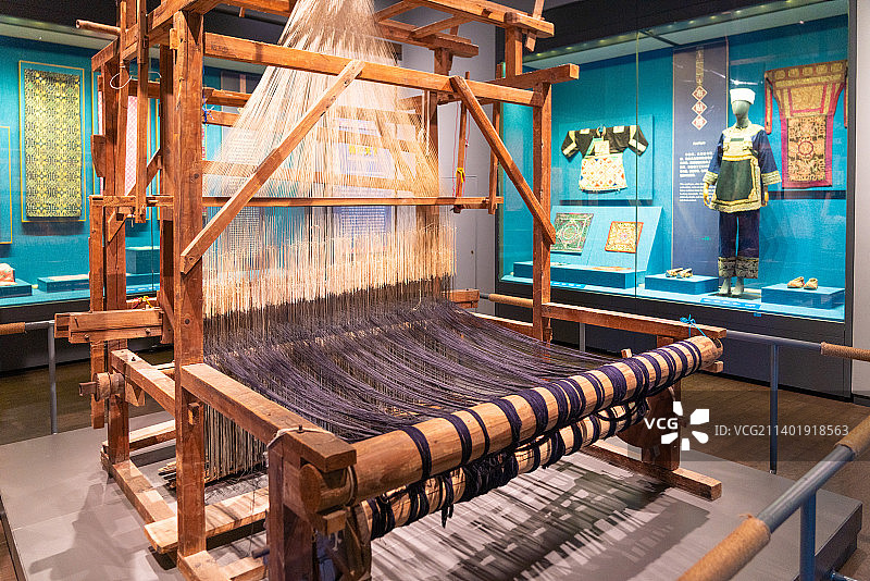 广西民族博物馆展品织布机与民族衣物图片素材