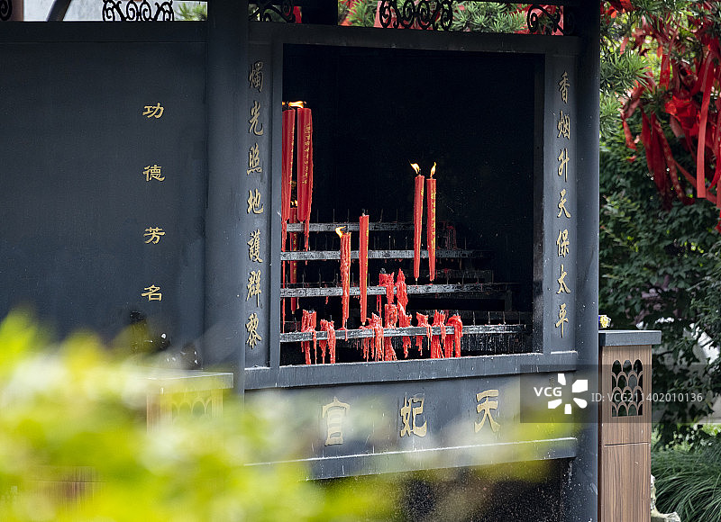 太仓浏河古镇天妃宫妈祖庙的香炉，上面插着一排排的红色香烛正在燃烧图片素材
