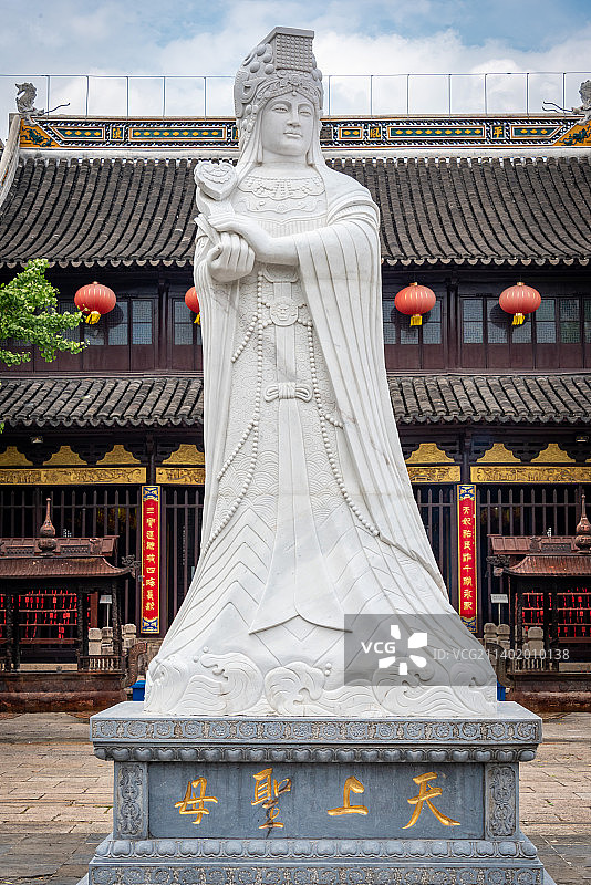 太仓浏河古镇天妃宫妈祖庙远景，蓝天白云下洁白的汉白玉妈祖雕像巍然耸立，背后是中国传统寺庙建筑和红灯笼图片素材
