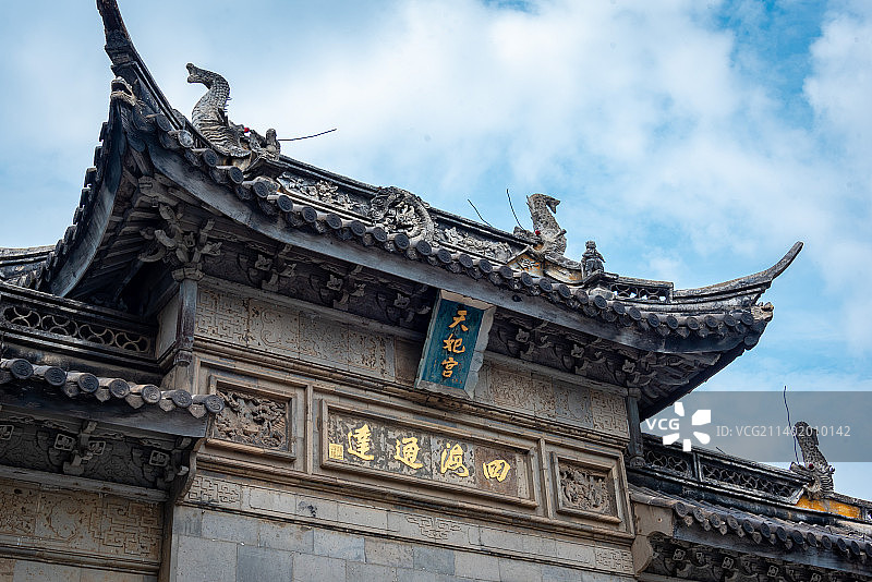 蓝天白云下太仓浏河古镇天妃宫妈祖庙古色古香的入口，牌坊上书四海通达和蓝底金字天妃宫牌匾图片素材
