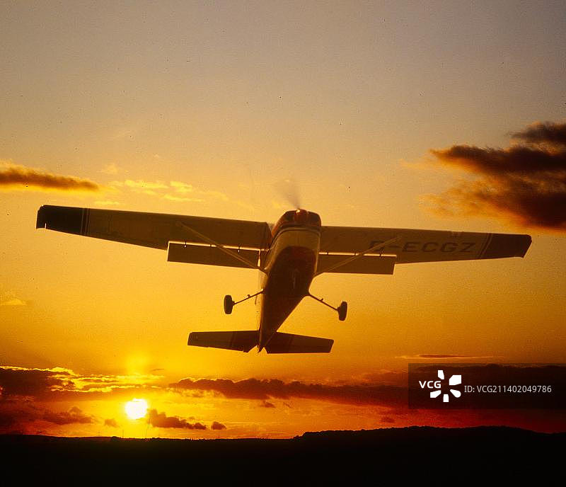 夕阳下的天空中的飞机：历史引擎双翼飞机航展图片素材