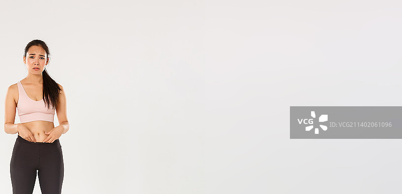 穿着健身服的沮丧亚洲女孩全身照图片素材