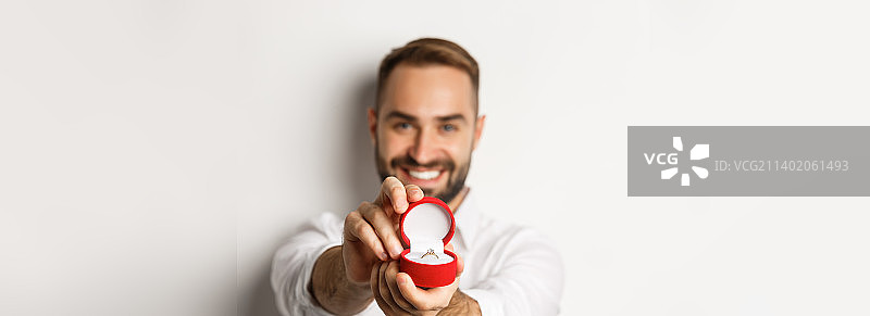 英俊男子求婚，聚焦戒指盒特写图片素材