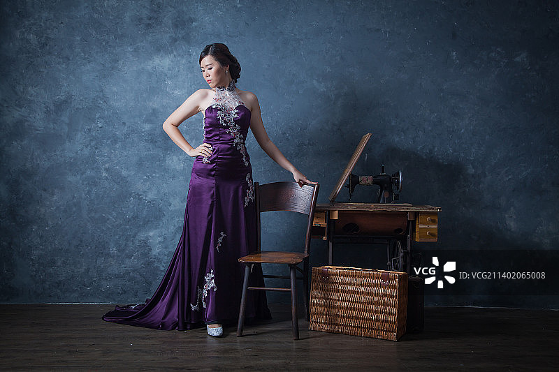 身穿传统服装的女子站在墙边，布城，马来西亚图片素材