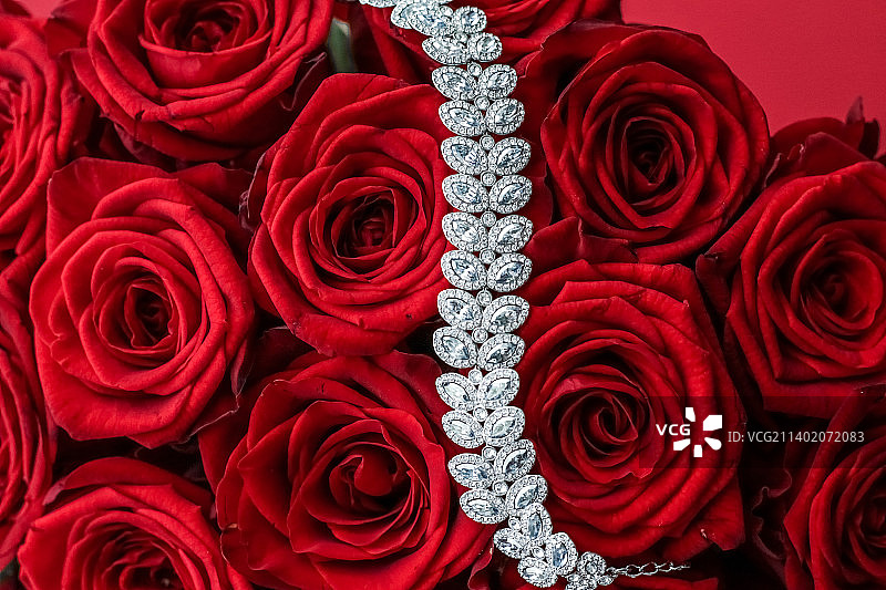 奢华钻石手镯和红色玫瑰花束，珠宝爱情礼物图片素材