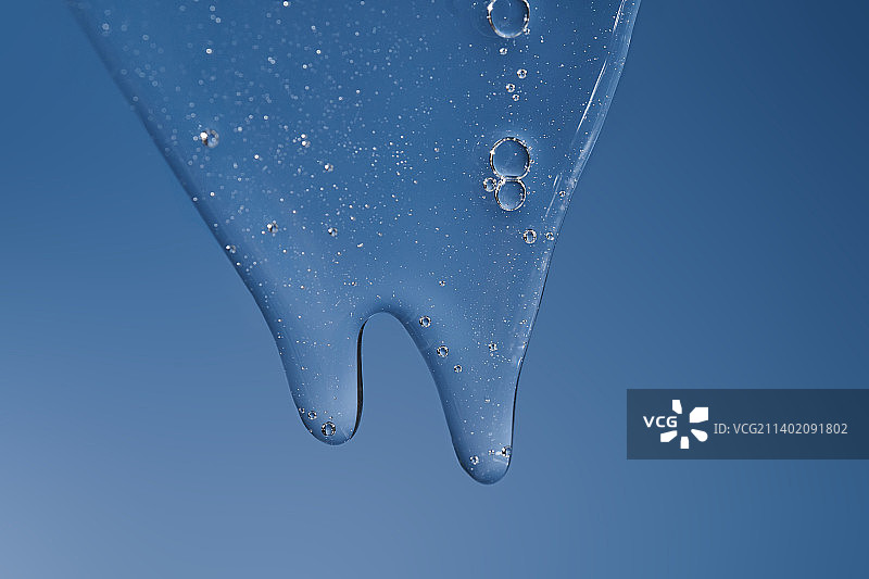 蓝色背景上流下的凝胶或洗发水纹理图片素材