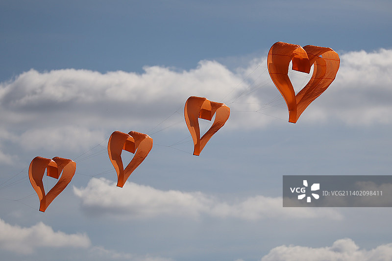 低角度拍摄的心形气球飞向天空图片素材