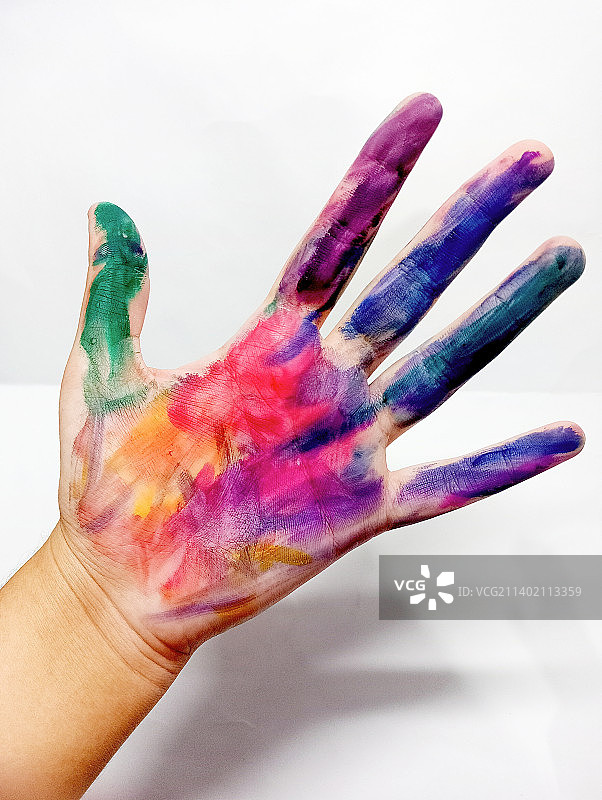 手持彩色粉末颜料的局部特写，背景为白色图片素材