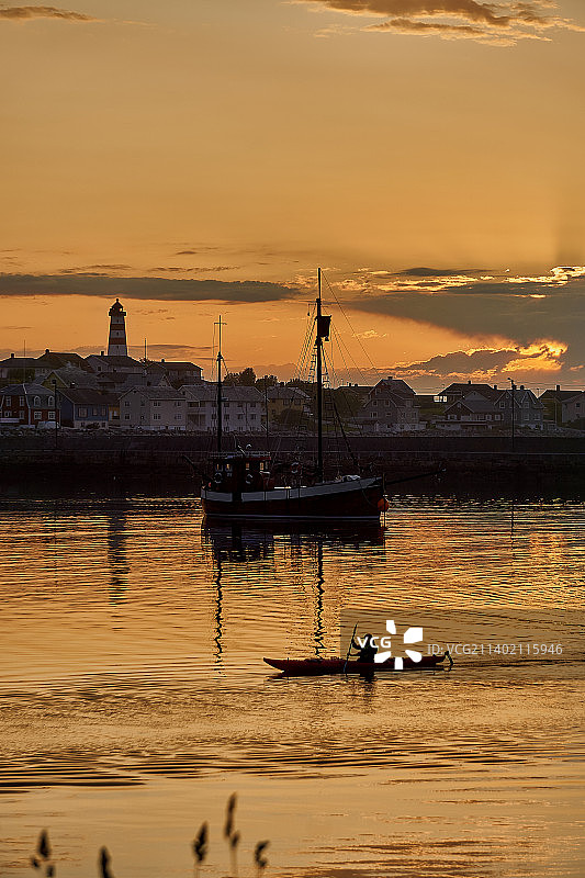 挪威奥尔内斯日落时分海面上帆船的轮廓图片素材