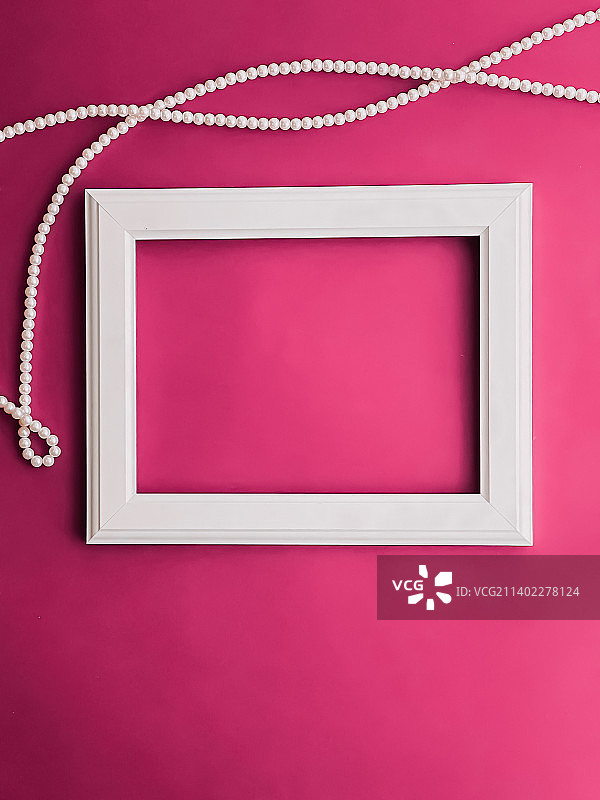 粉色背景上的白色横版艺术画框和珍珠首饰图片素材