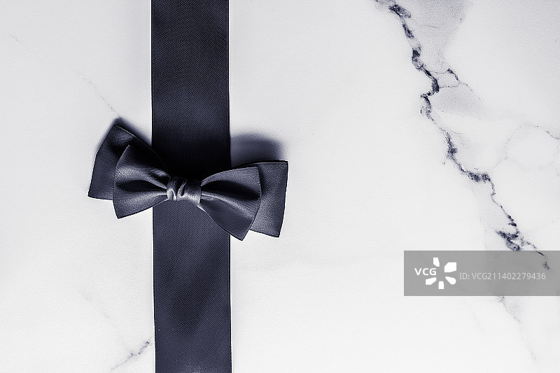 大理石背景上的黑色丝带和蝴蝶结，平铺图片素材