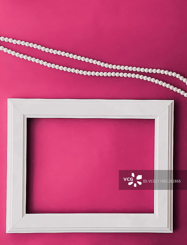 粉色背景上的白色横版艺术画框和珍珠首饰图片素材