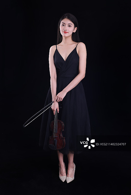 黑色背景里拉小提琴的年轻女性图片素材