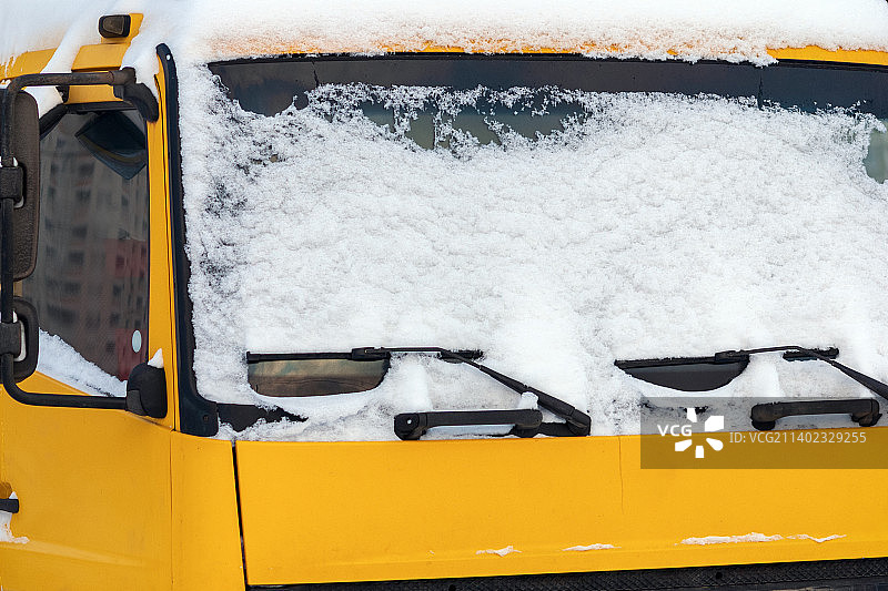 黄色卡车挡风玻璃上的雪图片素材