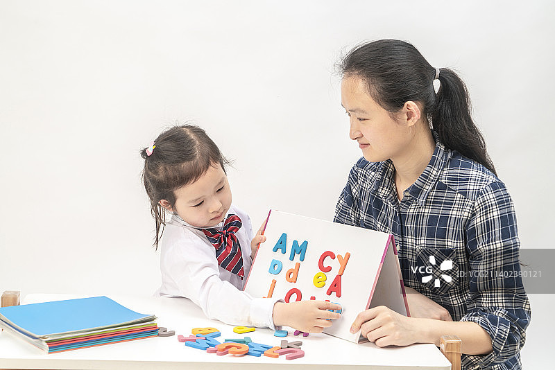小女孩和妈妈一起学英语图片素材