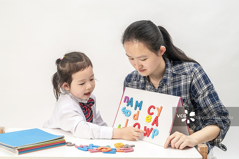 小女孩和妈妈一起学英语图片素材