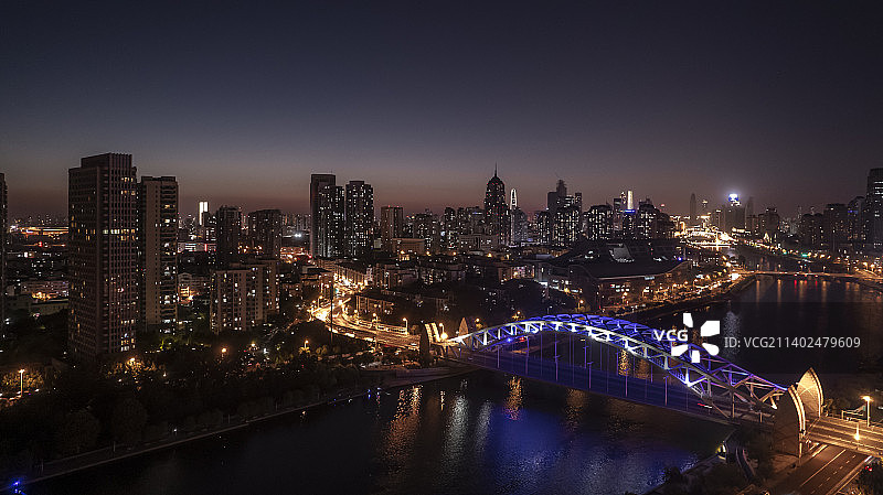 日落河边城市夜间照明建筑的高角度透视（天津海河国泰桥）图片素材