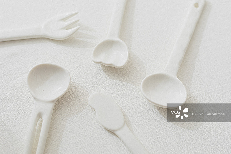 桌子上的白色陶瓷餐具勺子叉子黄油刀图片素材