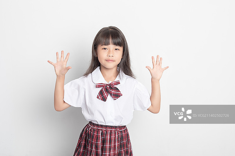 纯色背景中一个中国小学生伸出五根手指图片素材