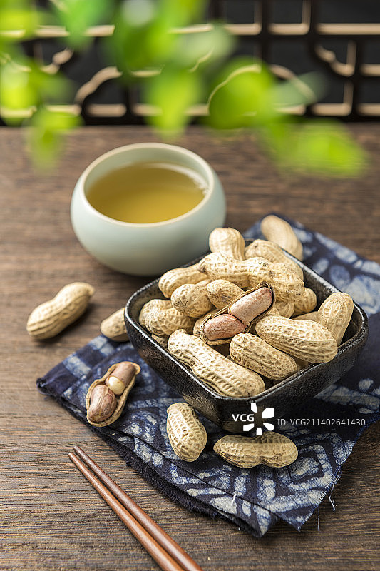 一盘蒜味花生摆放在木桌面上特写图片素材