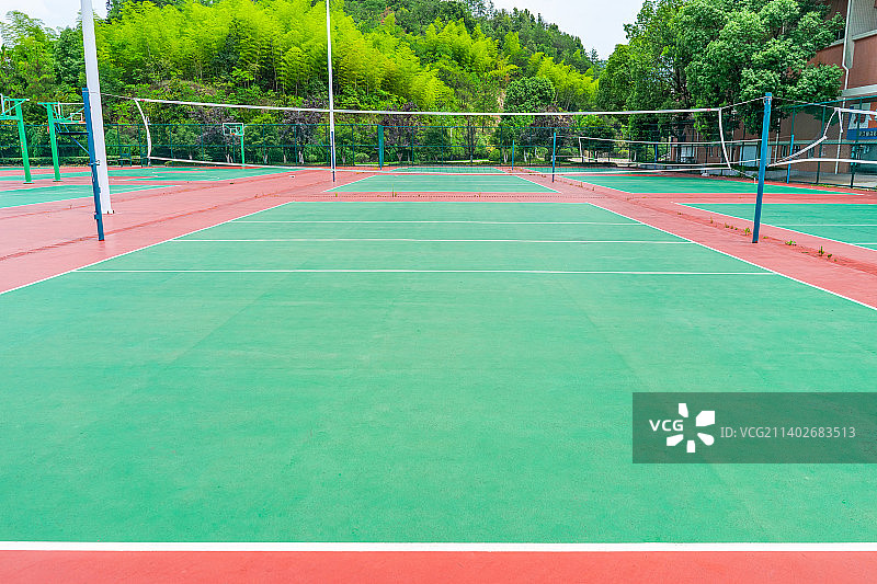 中国户外运动拍摄主题，网球场绿色的塑胶地面和长的网子，四周的照明设备，户外白昼无人图像摄影图片素材