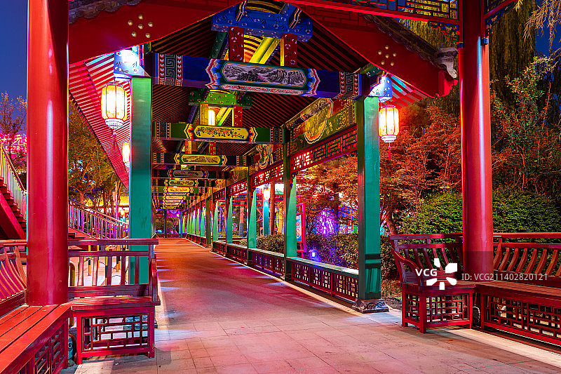 中国非都市风光拍摄主题，山东省泰安市岱岳区老街商业街，夜晚的泮河公园，弯曲的长廊步行道路和照明设备图片素材