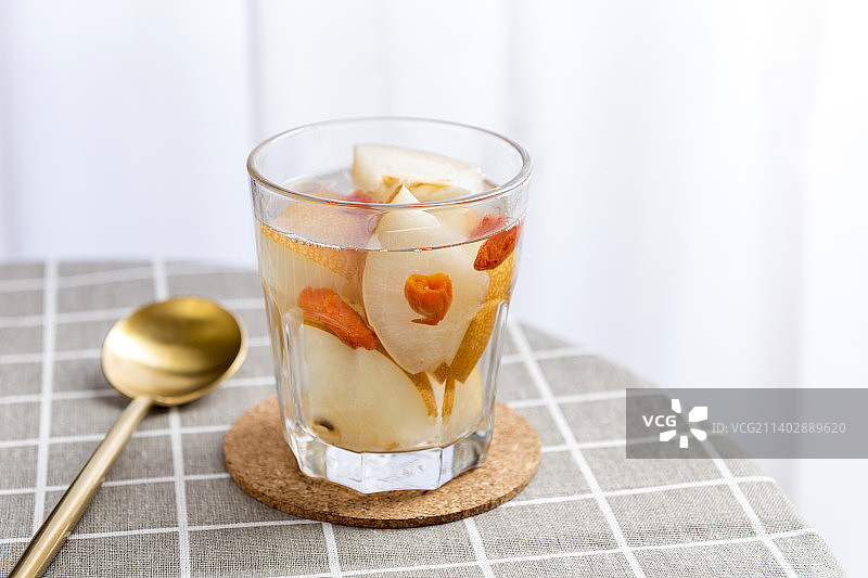 一杯冰糖秋月梨汤摆放在格子桌布上特写图片素材