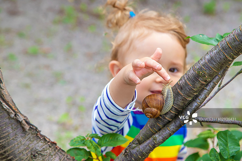 孩子看着蜗牛图片素材