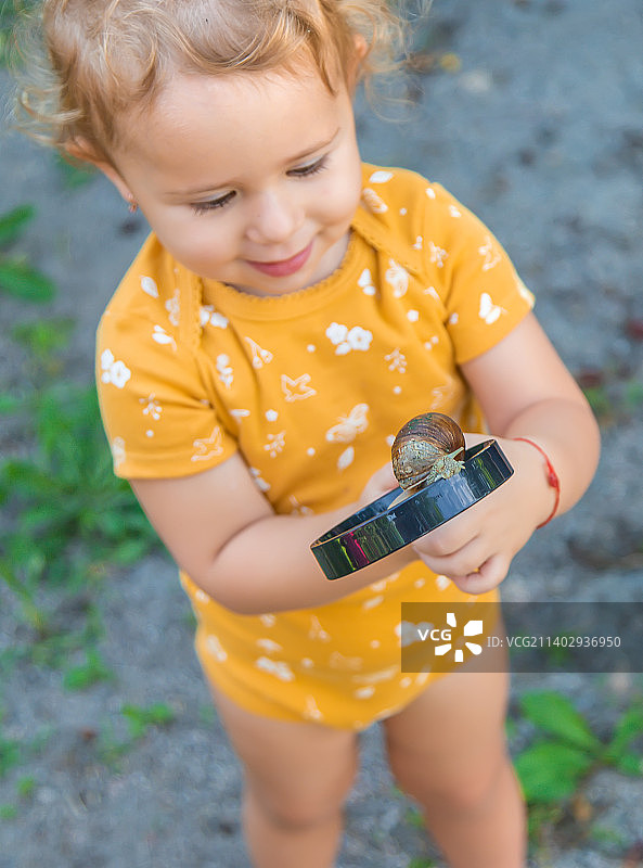 孩子看着蜗牛图片素材