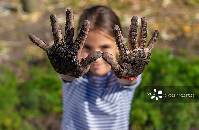 孩子在花园里捧着泥土图片素材