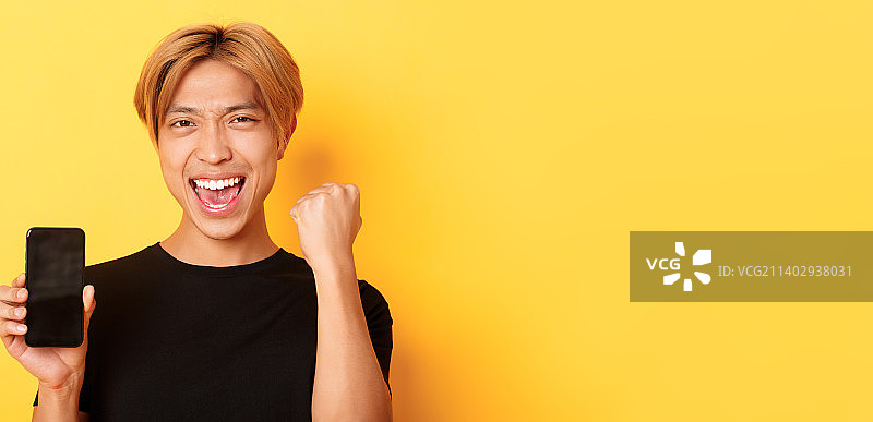 快乐的亚洲男子展示智能手机屏幕特写图片素材