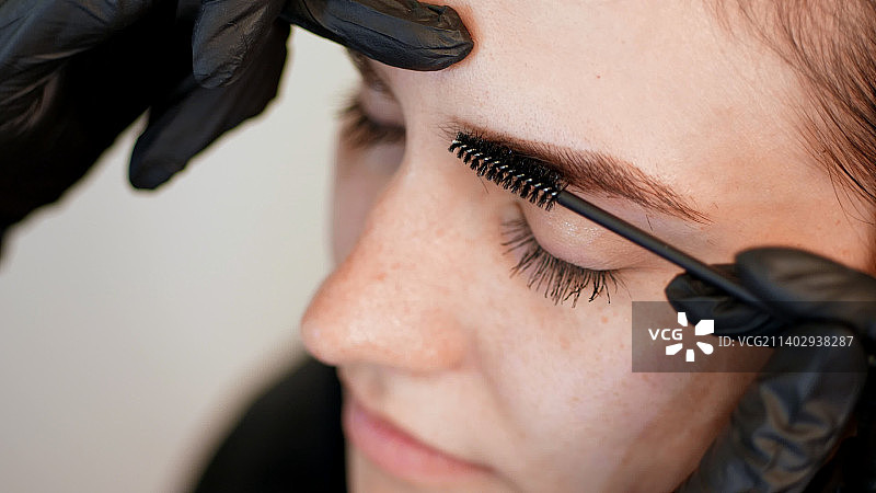 美容院特写：美容师戴黑色橡胶手套的手图片素材