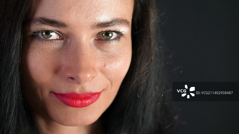 涂着红色口红的迷人深色头发女性肖像图片素材