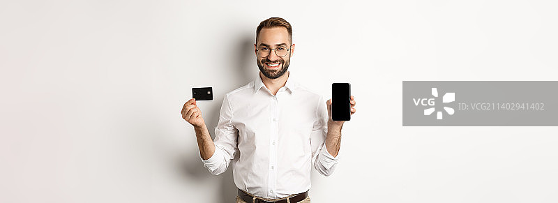 商务与在线支付：微笑的男士展示手机图片素材