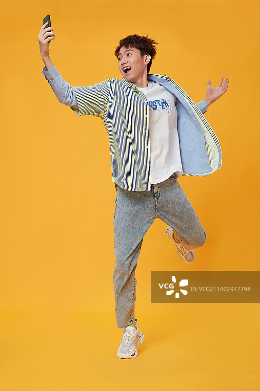 手拿手机的年轻男孩图片素材