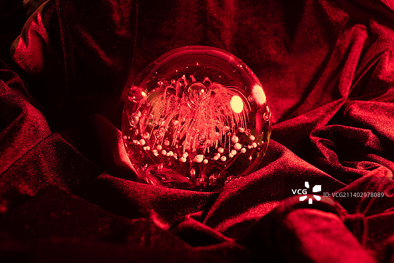 中国山东青岛红色天鹅绒布上的红色魔法玻璃球特写图片素材