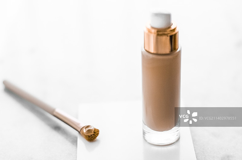 大理石上的粉底液瓶和轮廓刷，化妆品图片素材