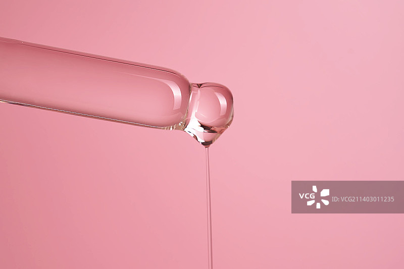 粉色背景上的精华或化妆油滴管图片素材