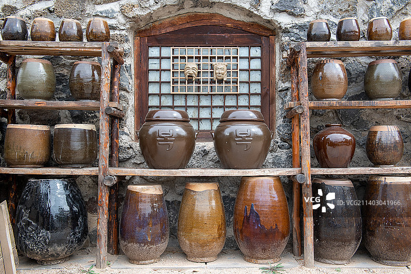 墙壁前木架摆满的酒缸图片素材