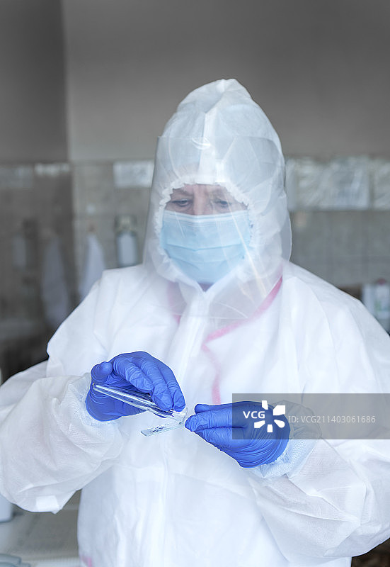 穿着防护服、戴着手套工作的女科学家图片素材