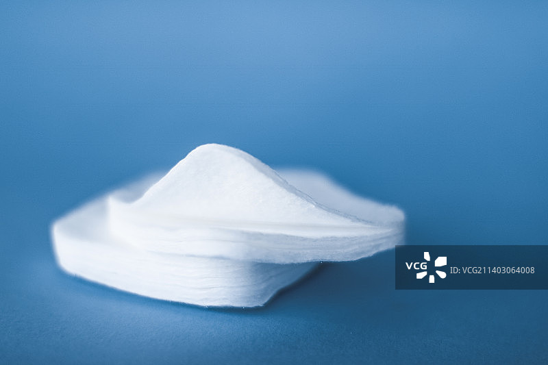 蓝色背景上的有机棉垫，化妆品和卸妆产品图片素材