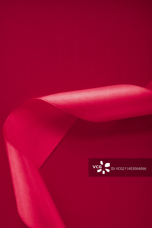 粉色背景上的抽象卷曲丝带，专属奢华品牌图片素材