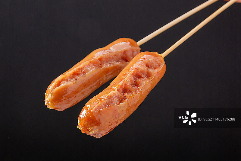 黑色背景前的火山石纯肉烤肠图片素材