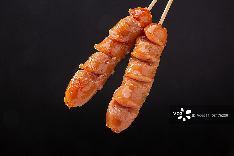 黑色背景前的火山石纯肉烤肠图片素材