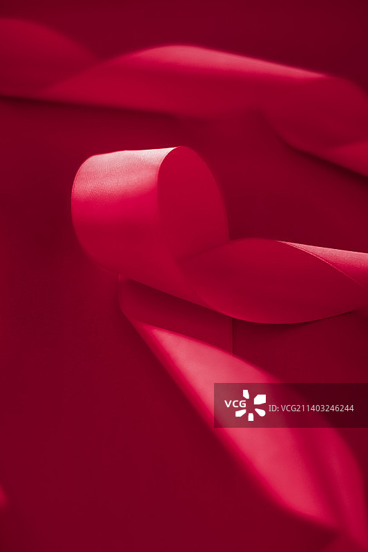 粉色背景上的抽象卷曲丝带，专属奢华品牌图片素材