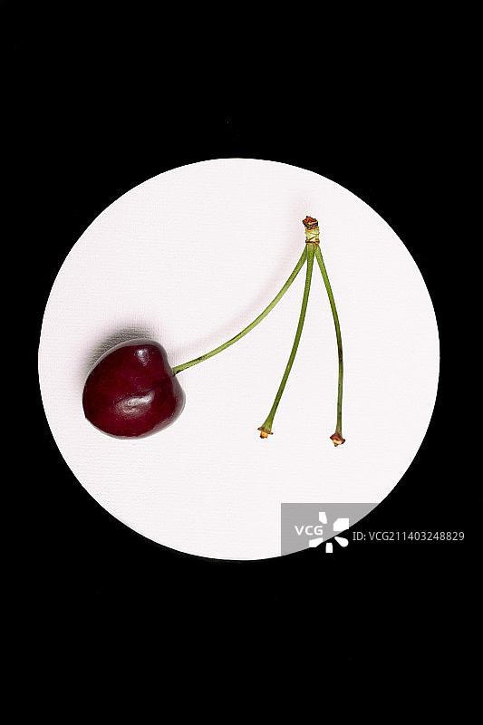 俯视视角：黑色背景上的盘装樱桃图片素材