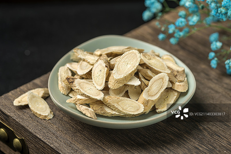 中药材黄芪摆放在古窗棂木桌面上特写图片素材